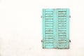 Rustic old grungy and weathered green cyan wooden closed window shutters with peeling paint Royalty Free Stock Photo