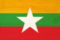 A rustic old Myanmar flag on weathered wood