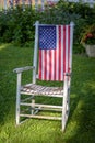 Rustic old white painted rocking chair sitting in lawn decorated Royalty Free Stock Photo