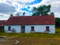 Rustic Old Whitewashed Irish Cottage with fiddler on roof Royalty Free Stock Photo