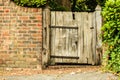 Rustic old wooden gate in brick wall Royalty Free Stock Photo