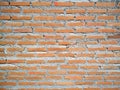 Rustic orange brick wall background with cement paste.