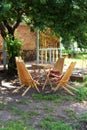 Rustic outdoor furniture for leisure time in nature. Empty chairs and table table in orchard. Autumn courtyard interior with garde Royalty Free Stock Photo