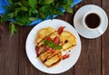 Rustic pancakes with fresh strawberries and chocolate on a white plate and cup of coffee. Royalty Free Stock Photo