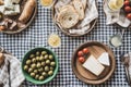 Rustic picnic spread with cheese, bread, olives, and fresh lemon drinks on checkered cloth Royalty Free Stock Photo