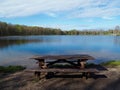 Rustic picnic table next to mountain lake Royalty Free Stock Photo