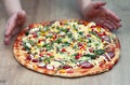 Rustic pizza with salami, mozzarella, olives and basil top view, copy space Royalty Free Stock Photo