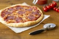 Rustic pizza with salami, mozzarella, olives and basil. Royalty Free Stock Photo