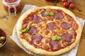 Rustic pizza with salami, mozzarella, olives and basil. Royalty Free Stock Photo