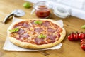 Rustic pizza with salami, mozzarella, olives and basil. Royalty Free Stock Photo