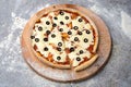 Rustic pizza on wooden board. whole pizza with tomato sauce, a lot of cheese with black Olives on top