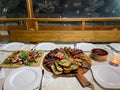 Rustic platter prepared for tourists with mici, pork neck on wooden platter