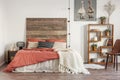 Rustic poster with two ducks, wooden bookshelf and double bed with pillows and duvet