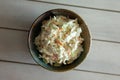 Bowl of coleslaw on a white table. Overhead view, shown from directly above with copy space.