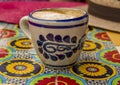 Rustic pottery on colourful table in cafe with straw hat in Mexico City