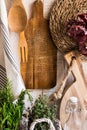 Rustic Provence kitchen interior, fresh herbs rosemary thyme, wood cutting boards, utensils, linen towel, dried peppers, glass bot