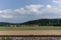 Rustic rail, green meadow, small village hill and cloudy blue sky. Colorful landscape near Tubingen, Germany