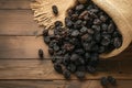 Rustic raisin display Black raisins in burlap bag on wooden table