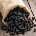 Rustic raisin display Black raisins in burlap bag on wooden table