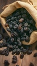 Rustic raisin display Black raisins in burlap bag on wooden table