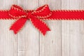 Red Christmas bow and ribbon top border on old white wood Royalty Free Stock Photo