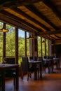 Rustic restaurant room of a mountain hotel, with large windows overlooking the forest and the mountains, luxuriously decorated