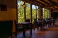 Rustic restaurant room of a mountain hotel, with large windows overlooking the forest and the mountains, luxuriously decorated