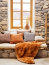 rustic room interior design, bench on background of window with stone wall, fur blanket with pillows