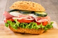 Rustic sandwich with ham, tomato, cucumber, mozzarella and green salad sheets Royalty Free Stock Photo