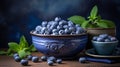 Rustic scene of ripe blueberries and fresh spearmint arranged in a clay bowl on a wooden table