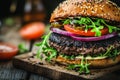 A rustic serving board featuring a homemade beef burger with crispy bacon and assorted vegetables. Royalty Free Stock Photo