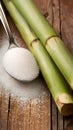 Rustic setup with granulated sugar spoon and sugarcane on wooden surface. Royalty Free Stock Photo