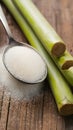 Rustic setup with granulated sugar spoon and sugarcane on wooden surface. Royalty Free Stock Photo