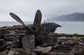 Rustic ship propeller on rocky shore Royalty Free Stock Photo