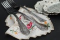 Rustic silver spoons collection on embroidery napkin on dark background