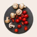 Rustic slate stone plate with tomatoes and mushrooms, copy space, isolated on white Royalty Free Stock Photo