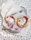 Rustic small galeta pies with fresh berries and vanilla ice-cream on silver dish over a piece of white linen fabric and floral pa Royalty Free Stock Photo