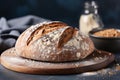 Rustic sourdough bread on wooden board in sunlit kitchen, showcasing traditional baking artistry Royalty Free Stock Photo