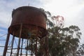 a rustic steel water tank from the bygone steam train era with lens flare Royalty Free Stock Photo