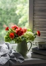 Rustic still life - autumn bouquet of hydrangeas and dahlias in a ceramic jug, books, a cup of green tea on a window with wooden Royalty Free Stock Photo