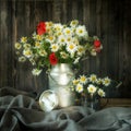 Rustic Still Life. Bouquet chamomile flowers and poppies in a metal can