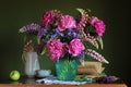 Rustic still life with bouquet of peonies, irises and lupins, an Apple and an book