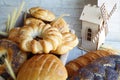 Rustic still-life with pastry in basket, spikelets of wheat and decorative wood wind mill