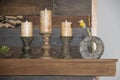 Rustic still life of wooden candle holders and candles and a flower sitting on a mantle against a reclaimed wood background Royalty Free Stock Photo