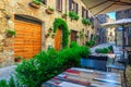 Rustic stone houses with flowery entrances and street cafe, Italy Royalty Free Stock Photo