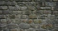 A rustic stone wall composed of unevenly shaped, weathered stones in various Royalty Free Stock Photo
