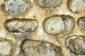 Rustic stone wall with embedded round rocks and weathered cement Royalty Free Stock Photo