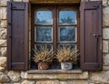 Rustic Stone Wall Window with Wooden Shutters and Dried Plants Royalty Free Stock Photo