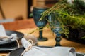 rustic style Christmas festive table, blue glasses, plates and fresh thuja branches bouquet. Eco-friendly elements Royalty Free Stock Photo