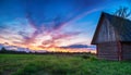 Rustic sunset. Skyline with log house in the foreground